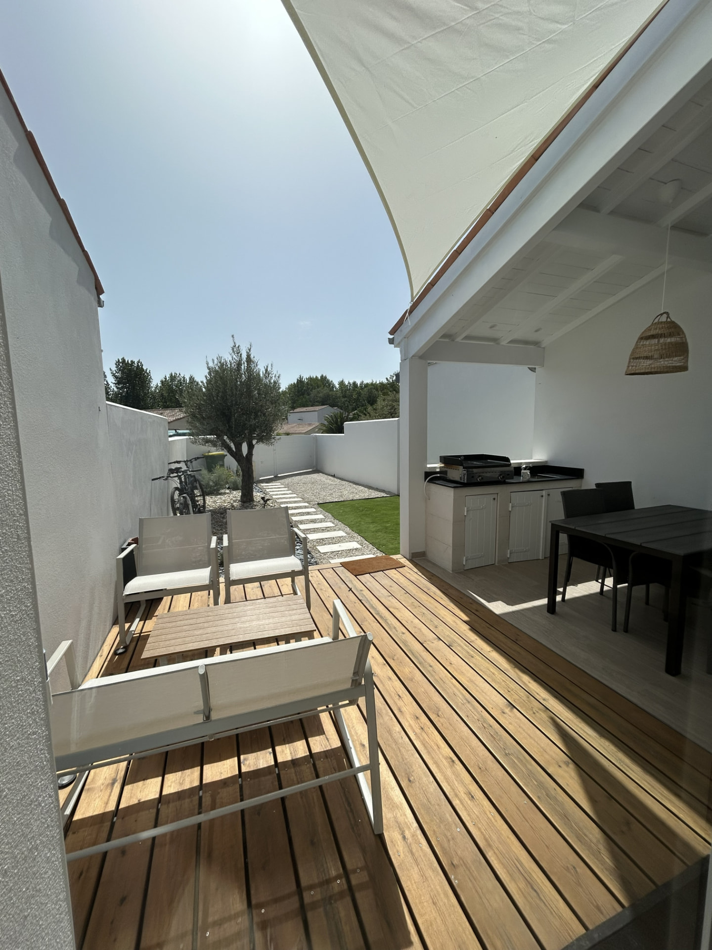 Terrasse avant couverte avec salon de jardin et voile d'ombrage